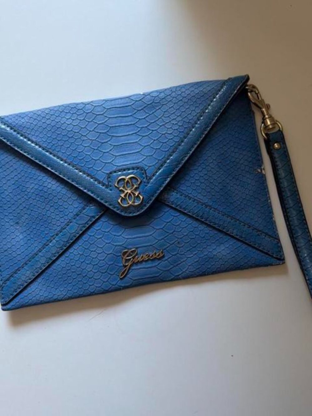 Blue Guess clutch with snakeskin texture